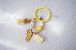 Key chain or bag charm on greyish white background. Top view. photo