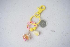 Key chain or bag charm on greyish white background. Top view. photo