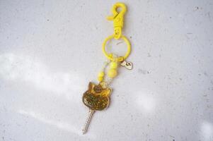 Key chain or bag charm on greyish white background. Top view. photo