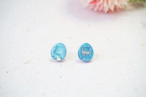 Close up of earrings on white background with pink carnation flower photo