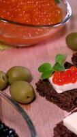 blanco un pan con mantequilla y rojo caviar. tradicional ruso Navidad y nuevo año aperitivo video