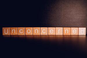 Wooden blocks form the text Unconcerned against a black background. photo