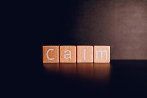 Wooden blocks form the text Calm against a black background. photo