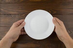 Hands hold an empty white plate photo