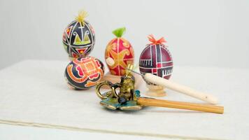 speciale dispositivi per colorazione uova quattro uova di diverso colori rosso giallo nero con ciuffi di filo su un' bianca sfondo spazio per testo cartolina Pasqua uova vacanza celebrazione di Pasqua video