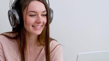 uditore sociale servizio bellissimo carino ragazza comunica al di sopra di Internet con amici il computer portatile cuffie lungo capelli dolce Sorridi anno Domini in linea corsi studia sociale reti vacanza all'estero viaggio Aiuto Internet video