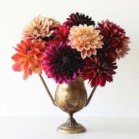 Vintage style brass vase holding a bunch of colorful dahlias. photo