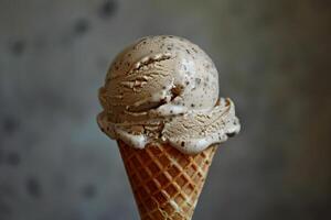 un cucharón de cremoso y de nuez avellana helado en un azúcar cono foto