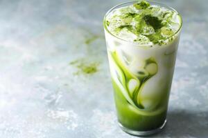 Iced matcha tea in a tall glass with milk. Sprinkle with matcha powder. photo