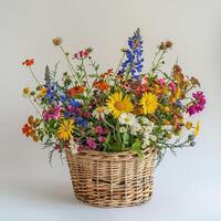 Rustic wicker basket filled with colorful wildflowers. photo