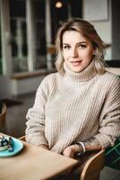 A woman enjoys a quiet meal, dressed in a cozy sweater with a watch on her wrist. The scene radiates comfort and contentment, perfect for lifestyle and dining-related themes photo