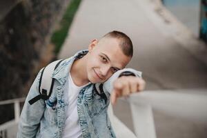 un joven hombre en un azul chaqueta y blanco camisa es sonriente foto