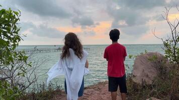 Vietnam phu Quoc island boy and a girl walk along the ocean watching the sunrise, the end of the sun, filming a walk through an untouched area video