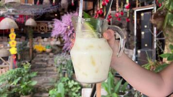 Kefir with ice Cold Indian drink Lassi, iced coconut Lassi drink with mint leaf, wooden background copy space video