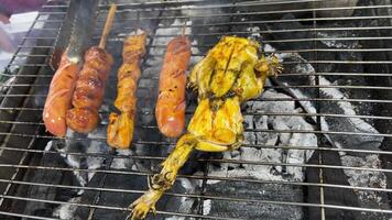 Frogs getting marinaded with a brush on a grill at Huanan market in Wuhan, China video