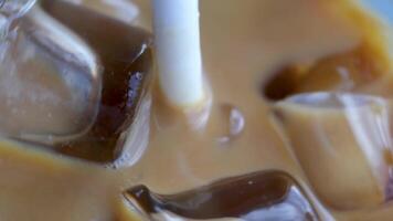 Ice latte with lactose-free milk oat or banana almond coconut milk in a delicious sweet drink close-up macro photography stir add ice several s video