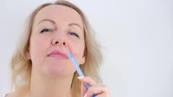 coçar a costas do a cabeça pensando com uma caneta pensativo mulher em pé dentro branco quarto com queda vermelho luz e sombra persianas. pensativo fêmea eu olhando às Câmera e coçar cabeça video