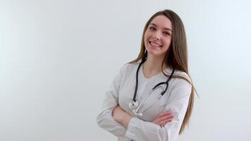 Beautiful young African American nurse or doctor with stethoscope stands, looking to the right side wearing blue scrubs and long curly hair video