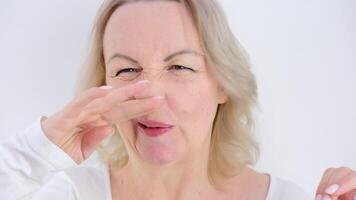 retrato de un joven mujer quien arañazos el nariz. alérgico reacción de el nariz. rinitis, sinusitis video