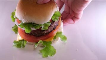 dobra uma hamburguer crio uma hamburguer cobrir com uma pão colocar cebola costeleta tomate derramar mostarda ketchup colocar queijo e alface espalhar maionese em a pão a todo processo dentro diferente s video