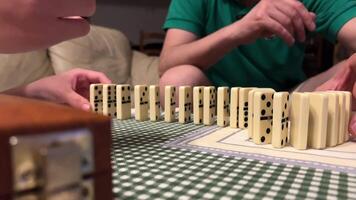 playing dominoes the hands of a girl and the hands of a man build dominoes video