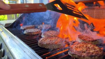 Grill zum ein Hamburger gekocht auf ein öffnen Feuer und gedreht Über Fleisch Pastetchen Boden gehackt Fleisch bereit gebraten und sehr lecker Wende Über mit ein Spatel auf Feuer. das Feuer gerade brennt und ist sehr lecker video