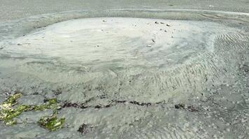 the dark sand of the Pacific Ocean, Vancouver Island, it is clear that the water went into the sea and blur after the water raged on the shore, traces are visible very quietly and calmly video