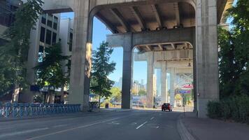 Granville Island Cars drive under the bridge people cross the road seething life Vancouver Canada video