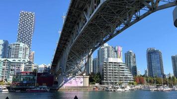 Granville Street Bridge Clear blue sky and the Pacific Ocean are visible skyscrapers Slow motion camera floats by filming a beautiful bridge video