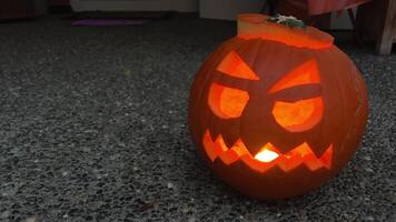 gesneden halloween pompoen lit een vlam binnen, in de omgeving van de rook reizen langs Aan een zwart achtergrond met verlicht kaarsen dichtbij omhoog. slowmotion video