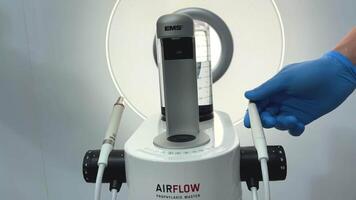 doctor turns on Airflow Device for deep cleaning of teeth from tartar Cleaning stones and plaque The newest apparatus on a white background Dentistry new inventions video