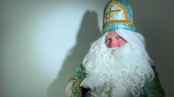 Heilige Nikolaus Blicke aufmerksam streicheln seine Schnurrbart seine Bart Zweifel Interesse aussehen beim das Kamera auf ein Weiß Hintergrund Schatten Nikolaus das Wundertäter, Heilige Nikolaus, das Gründer von Santa video