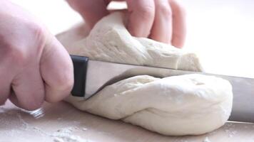 vrouw handen besnoeiing uit zacht deeg met mes en schudden het deeg Koken brood vrouw bladeren het Aan tafel en duurt handen heerlijk familie gebakje restaurant blok culinaire Frans manicure licht tafel video