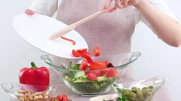 menina acrescenta fatiado cereja tomates vegetal salada com branco prato de madeira colher Pimenta azeitonas pepinos nozes nozes vegetariano Comida restaurante fruta e vegetal mercearia loja artigos de vidro video