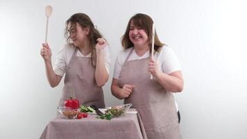 2 mulheres dançando enquanto preparando saboroso e saudável Comida vegetariano vegetal nora de salada sogra amigáveis família Lugar, colocar para texto publicidade mercearia loja saudável Comida Entrega video