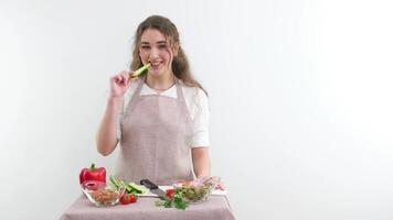 grön vegan sallad med blandad grön löv kvinna äter sallad på tabell med organisk grönsaker, njuter friska diet, stående i ljus kök interiör. lady kokta veggie måltid vikt förlust begrepp video