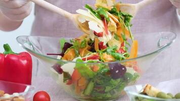 vegetable salad in glass plate stirs woman top mixed with vegetables carrots spinach arugula tomatoes red bell peppers cucumbers diet vegetarian takeaway tasty healthy doctor prescribed video