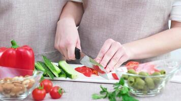 Couple preparing a meal cut bell pepper Close up cropped image of cutting board and couple cutting vegetables in the kitchen together, preparing food meal at home. Vegetarian healthy food video