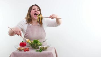 funny cheerful woman eating salad wooden spoon stuffs portion of food weight loss advertising healthy food vegetarian food woman in body full juicy banner white background glassware good appetite video