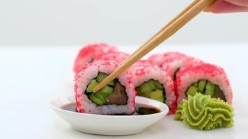 Traditional delicious fresh sushi roll set on a black background. Sushi roll with rice, nori, cream cheese, tobiko caviar, avocado. Sushi menu. Japanese kitchen, restaurant. Asian food video