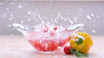 auf ein Weiß Hintergrund. schleppend Bewegung.langsam Bewegung Kirsche Tomaten fallen in klar Wasser ein Menge von spritzt um auf das Tabelle Gemüse waschen Essen Keim Schutz Gesundheit Vitamine richtig Ernährung video