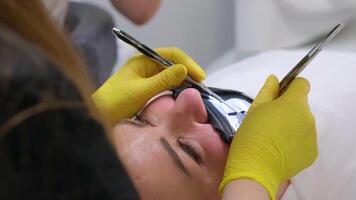 odontologia Reveja do a prevenção do dental cárie. uma mulher dentro a Dentistas cadeira durante uma dental procedimento amarelo lavando luvas video