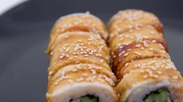 Sushi con riso e fresco pesce telecamera cavalcata su rotolo con anguilla. avvicinamento sparo. giapponese cucina unagi nigiri Anguilla Sushi su un' vassoio rotante video