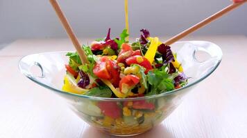 Pouring salad vinaigrette in bowl of healthy vegetable salad. Dressing salad video