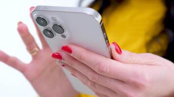fêmea mãos com Móvel telefone mulher folheando através Páginas fechar-se branco Móvel telefone laranja roupas mensagem Internet social redes video