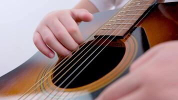 fermer de le enfant mains sur le guitare le garçon les coups le cordes en essayant à jouer étude à une la musique école se livrer dans l'amour musical instruments une Nouveau Regardez à la musique 5-7 ans vieux enfant video