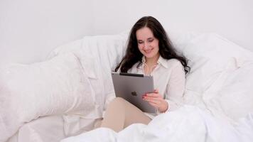 hermosa moderno mujer utilizando tableta computadora en lujo dormitorio video