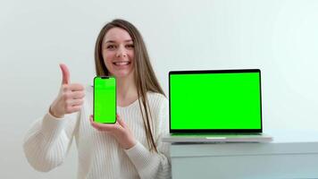 Young happy beautiful woman smiling while showing digital phone laptop video