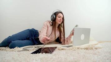 Indisch vrouw zitten Aan fauteuil in leven kamer met laptop voorzien professioneel begeleiding, genieten persoonlijk afgelegen gesprek gebruik telefoontje sollicitatie. virtueel evenement, comfort modern tech gebruik concept video