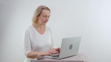 mulher sério foco digitando em computador portátil teclado para trabalhos a partir de casa durante quarentena coronavírus espalhar. fêmea dentro casual uniforme conectados trabalhando dentro casa para manter social distanciar video